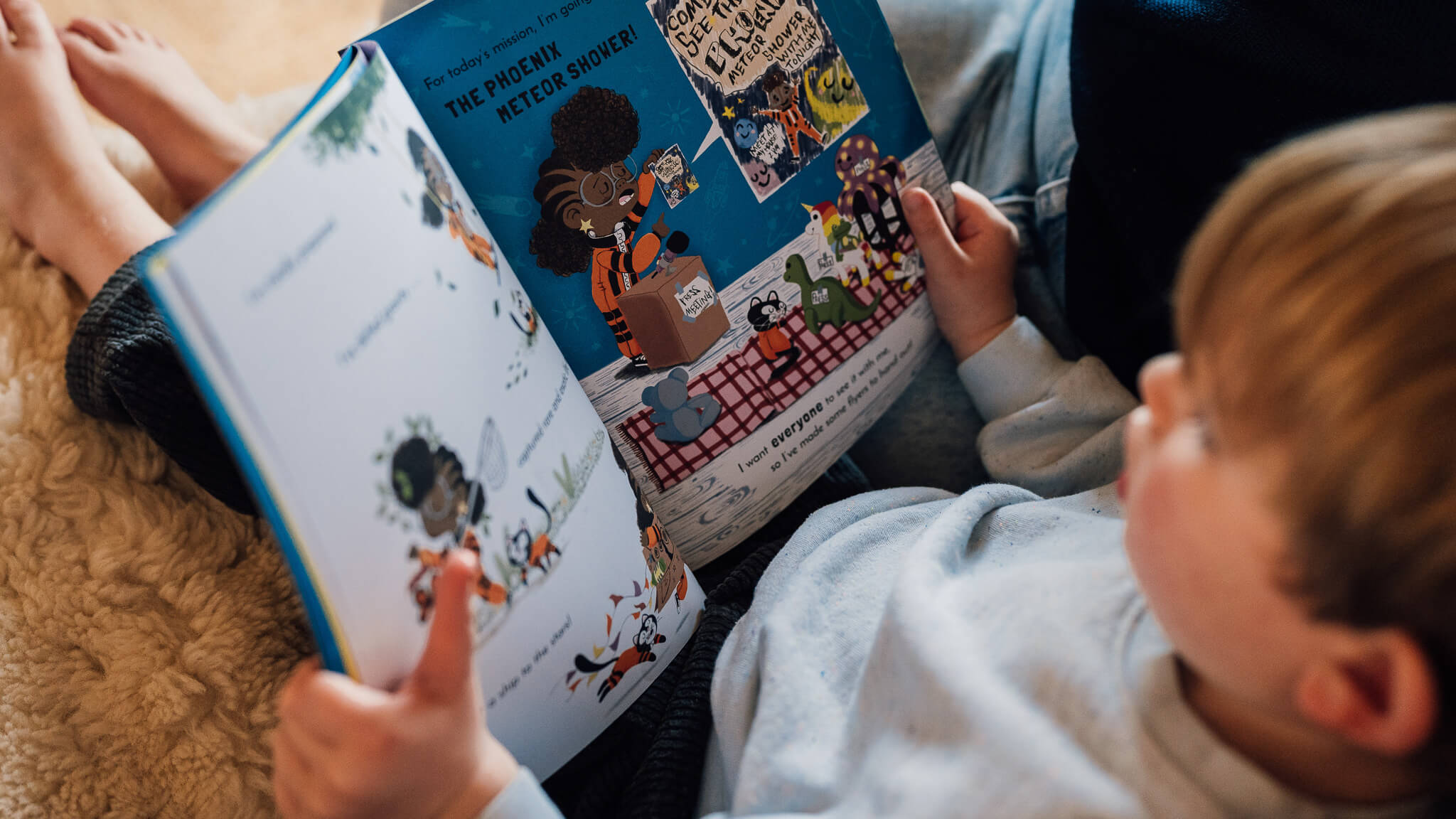 Person reading a children's book to a child with a focus on the book's illustrations.